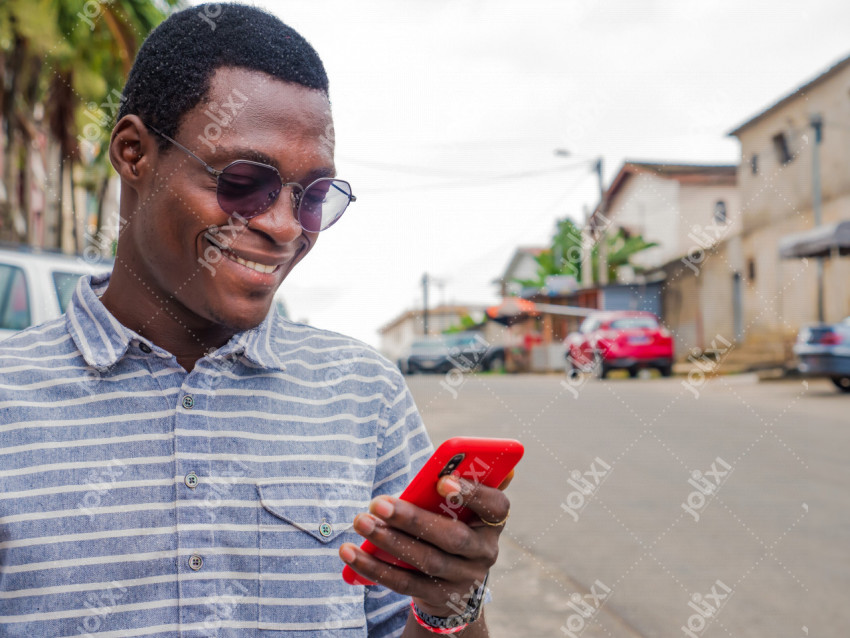Jeune homme africain content manipulant son smartphone - Photo #6306 -  Jolixi